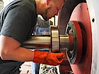 Electronics technicians mounting a roller bearing on the motor shaft