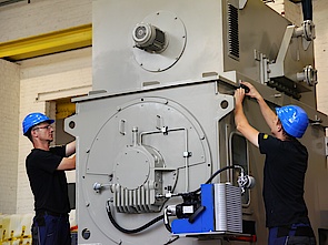 Electronics technicians mounting a 3000V motor for reciprocating compressor
